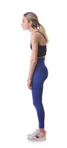 blonde irish dancer showing bad posture wearing blue yoga pants and black crop top
