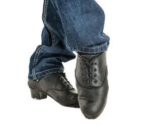 Irish dancer feet in black shoes isolated on white