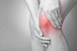 woman holding very red sore knee injury is irish dancing hard on the knees