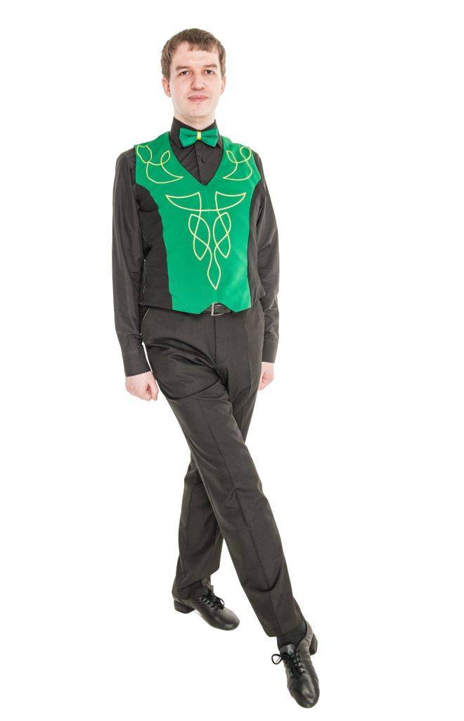 Irish dancing man with green vest and black shirt showing stiff arms