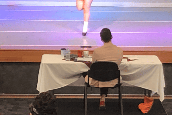 Irish dance adjudicator watching Irish dancer at a feis competition