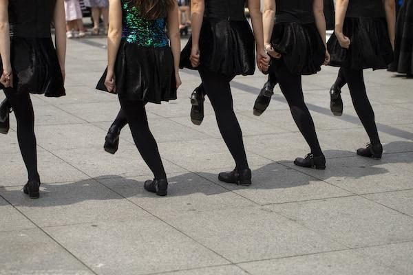 Irish Dancers doing street performance Irish dancing girls in courtyard wearing black and green costume and wearing heavy shoes