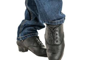 Irish dancer feet in black shoes isolated on white